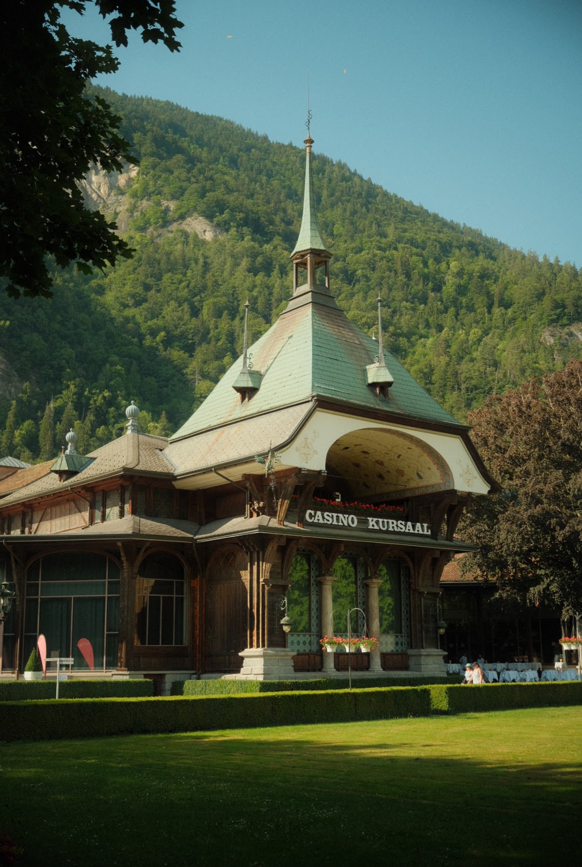 Casino Kursaal Interlaken's timber pavilion and green spire set against the wooded mountainside.