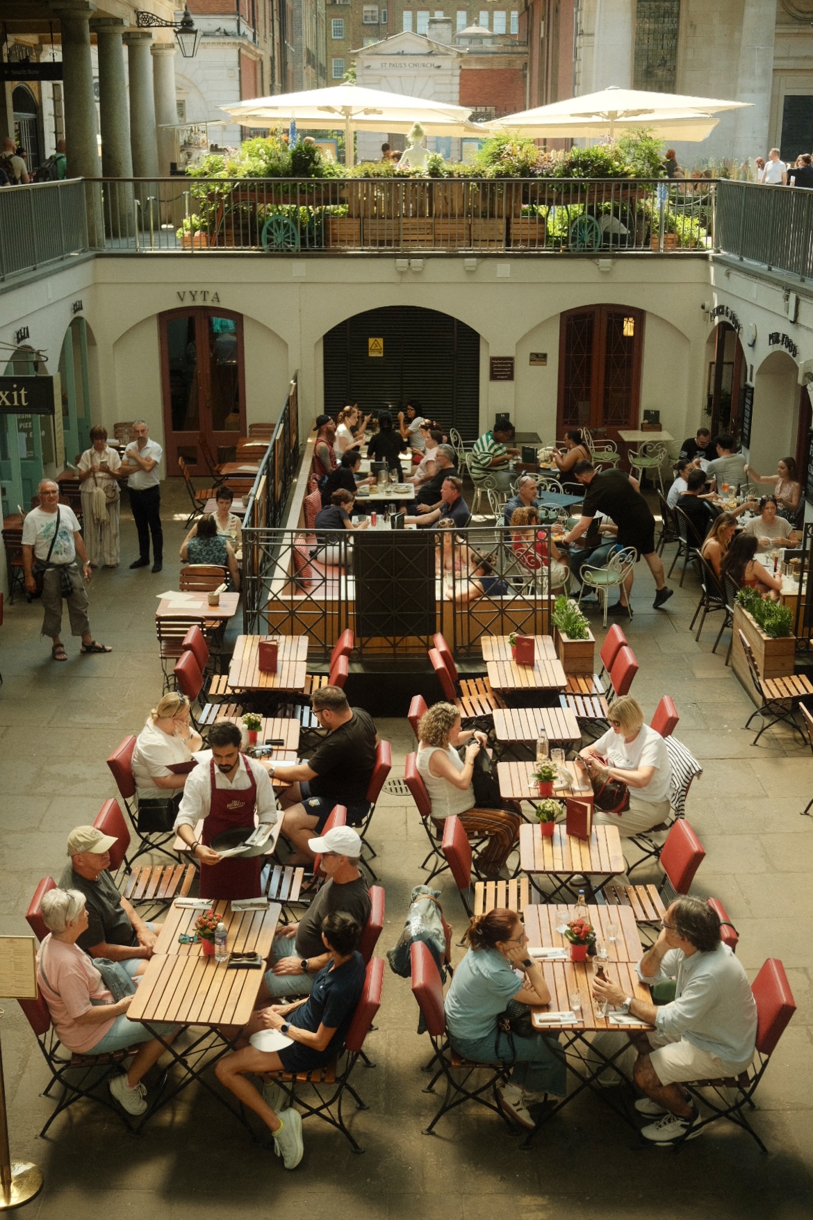Diners at an open-air cafe inside Covent Garden Market, London.