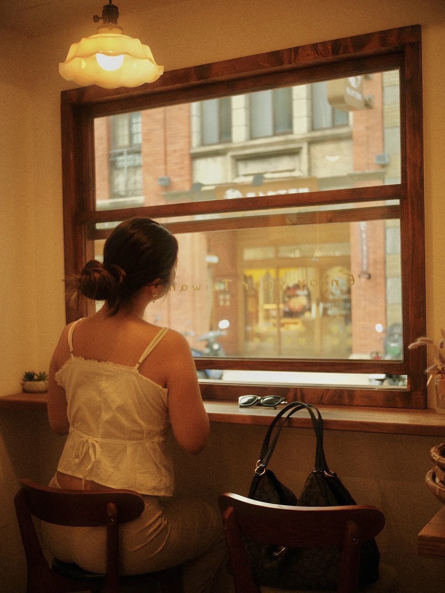 A warm cafe window looking out onto a Taipei street.