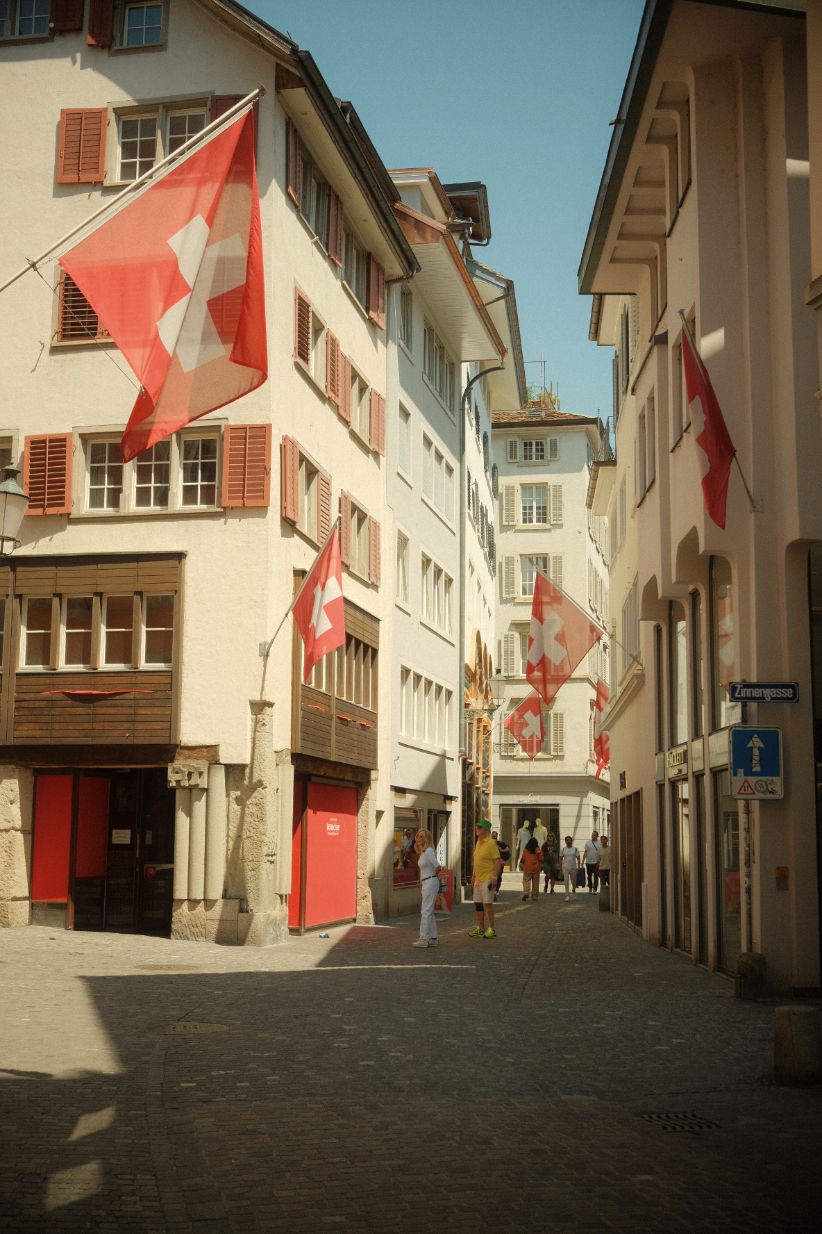 Swiss flags draped over a cobbled alley in Zurich's Altstadt.