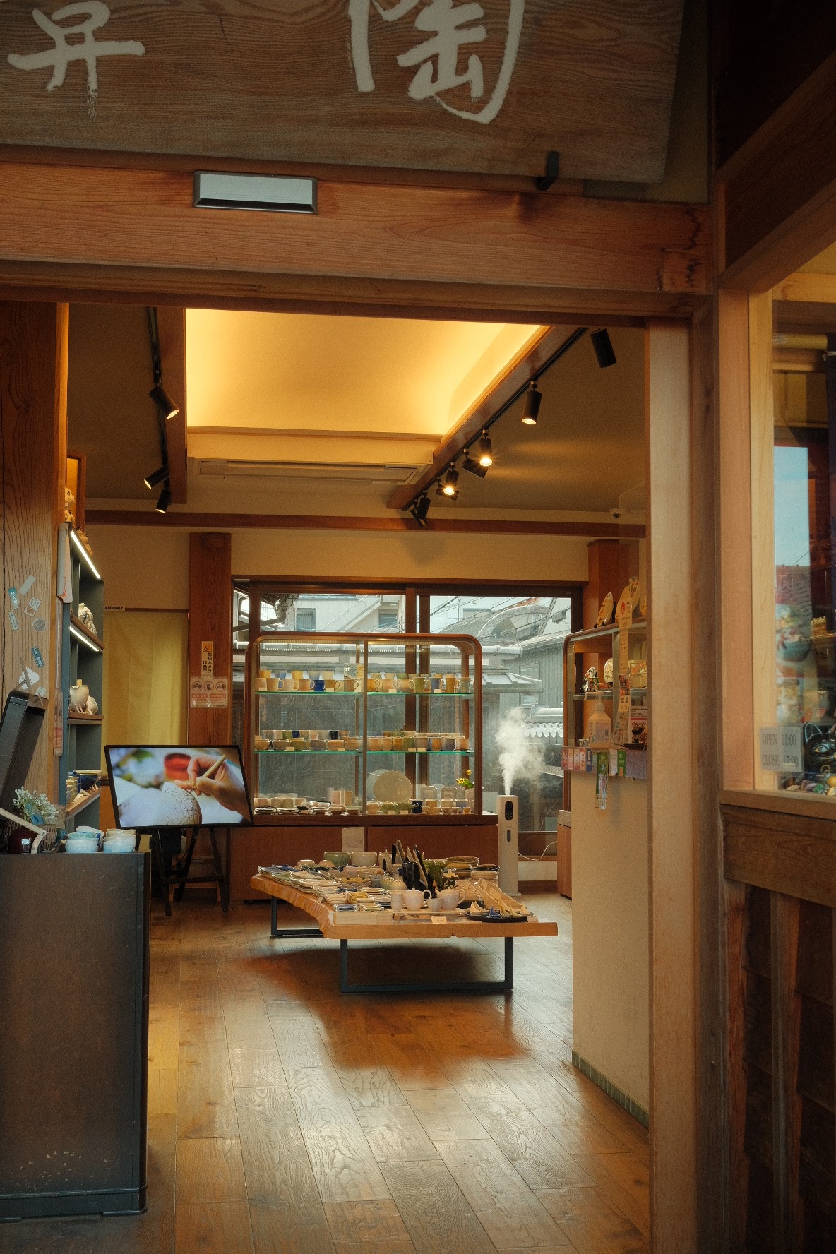 Interior of a traditional Japanese ceramics shop with warm wood and pottery displays.
