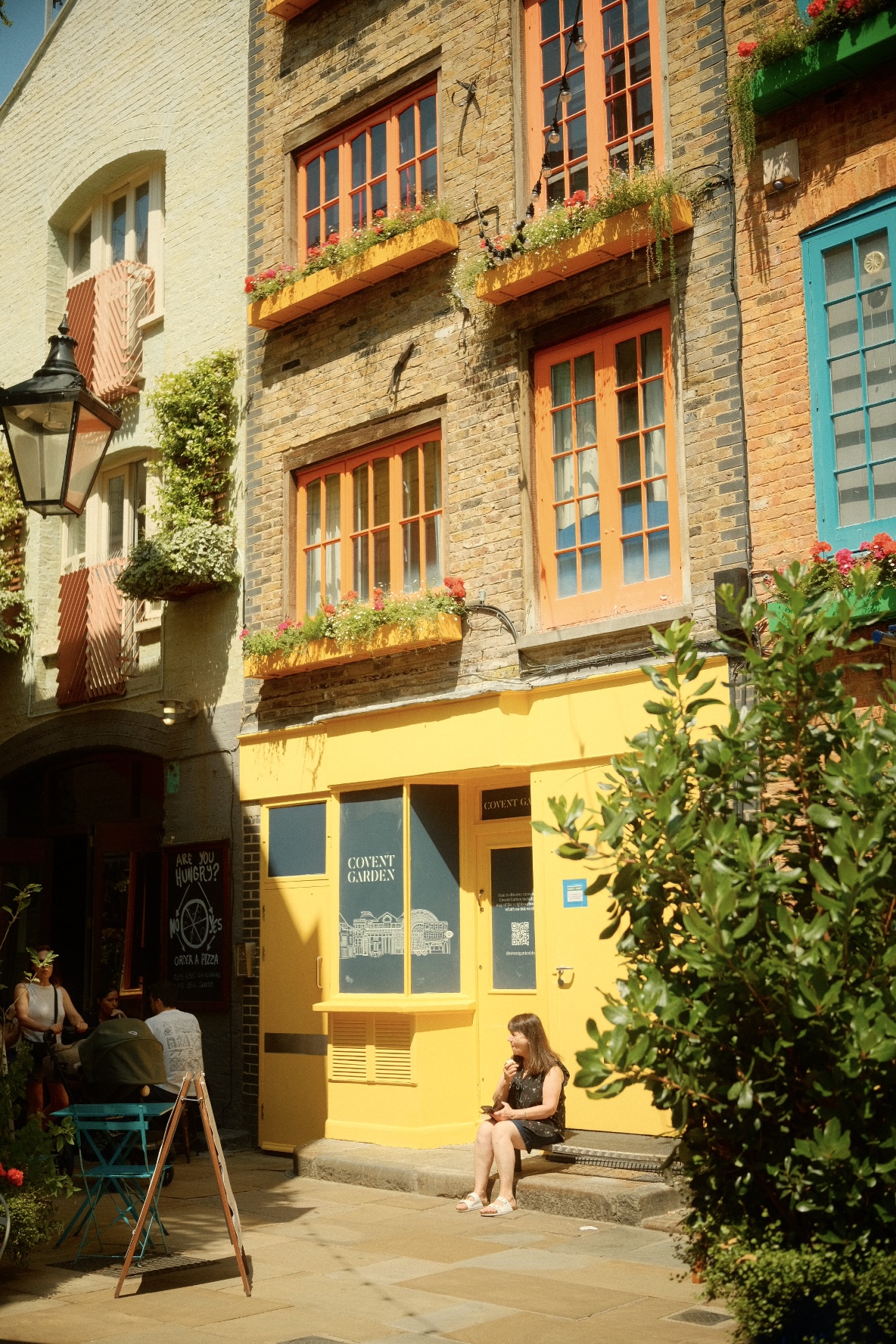 Yellow Covent Garden shopfront framed by greenery in Neal's Yard, London.