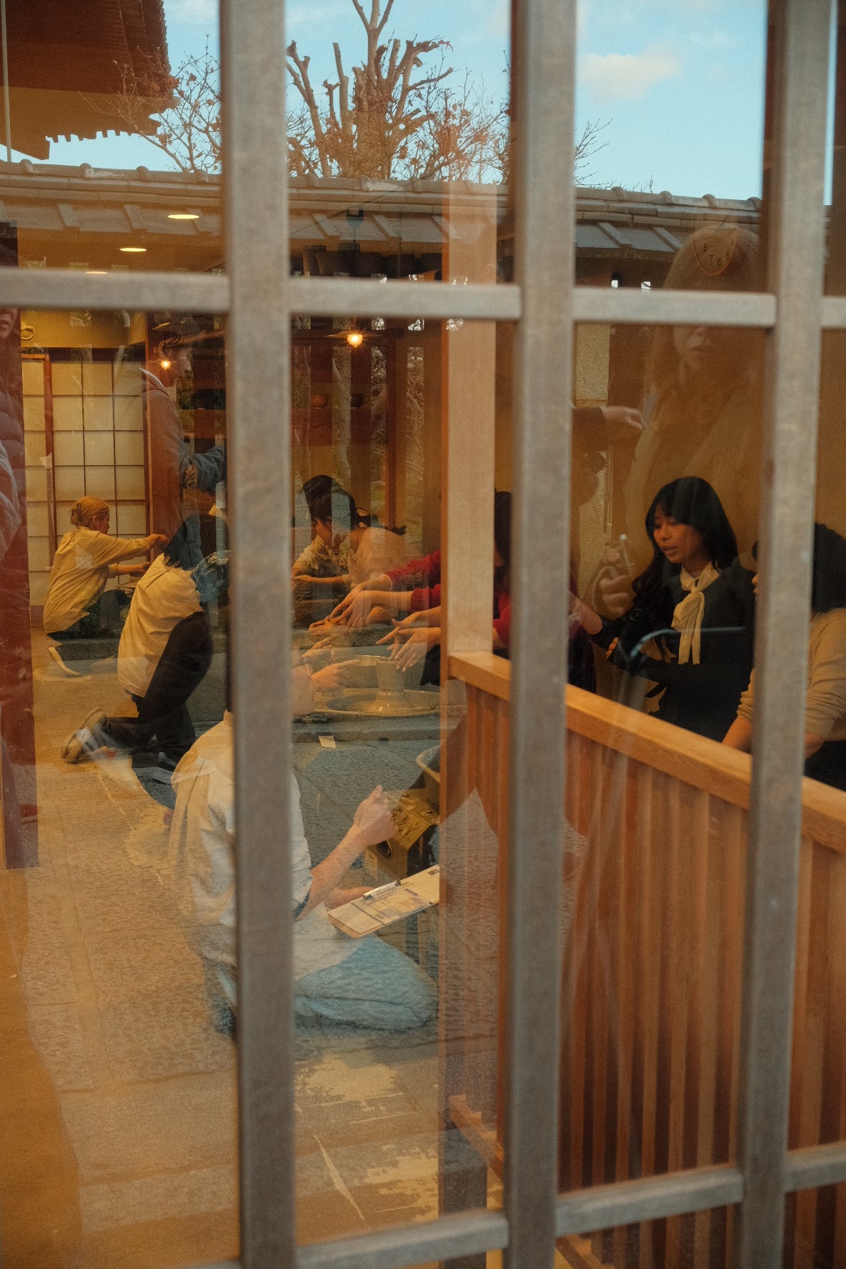 Reflections of a Kyoto pottery workshop seen through a wooden latticed window.