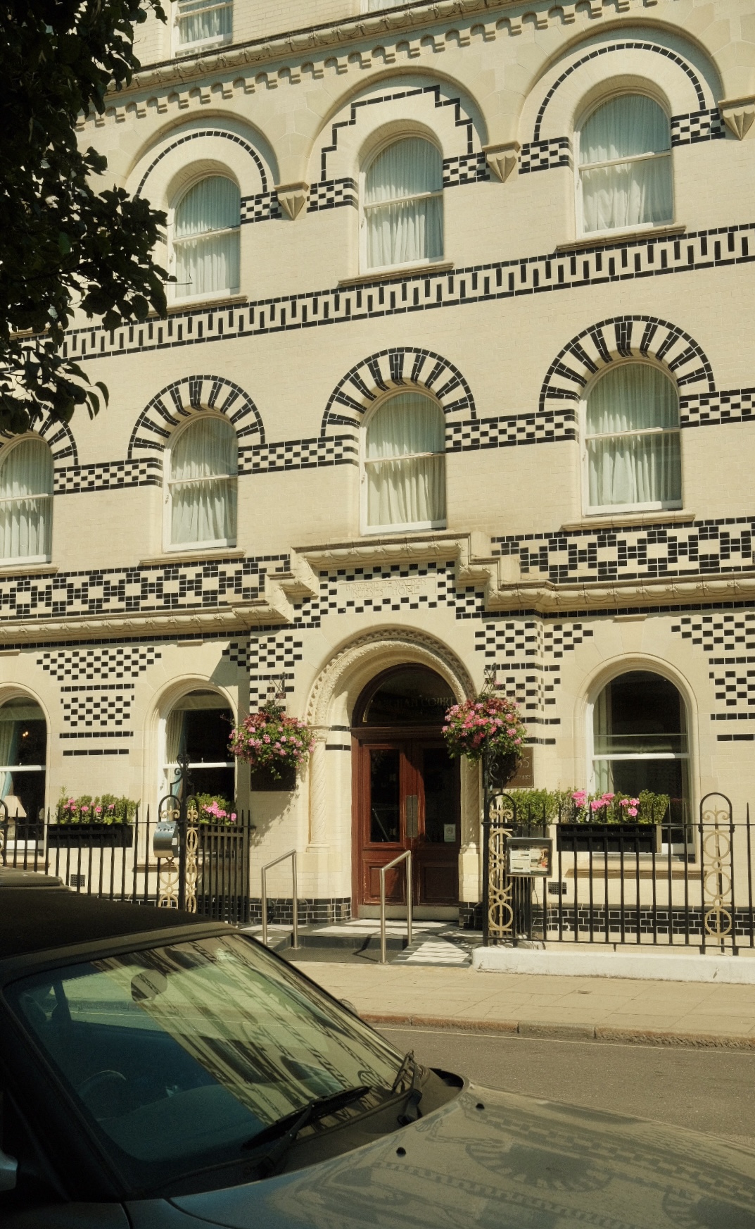 Ornate Victorian facade with checkered tilework in London.